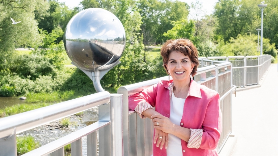 Information and Privacy Commissioner Patricia Kosseim posing for a photo on a bridge, with trees in the background.