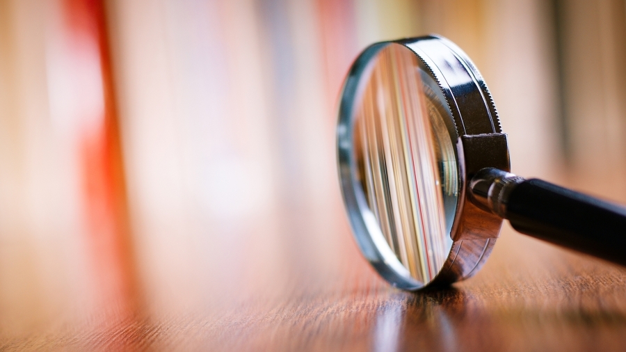 magnifying glass with folders in focus, background blurred