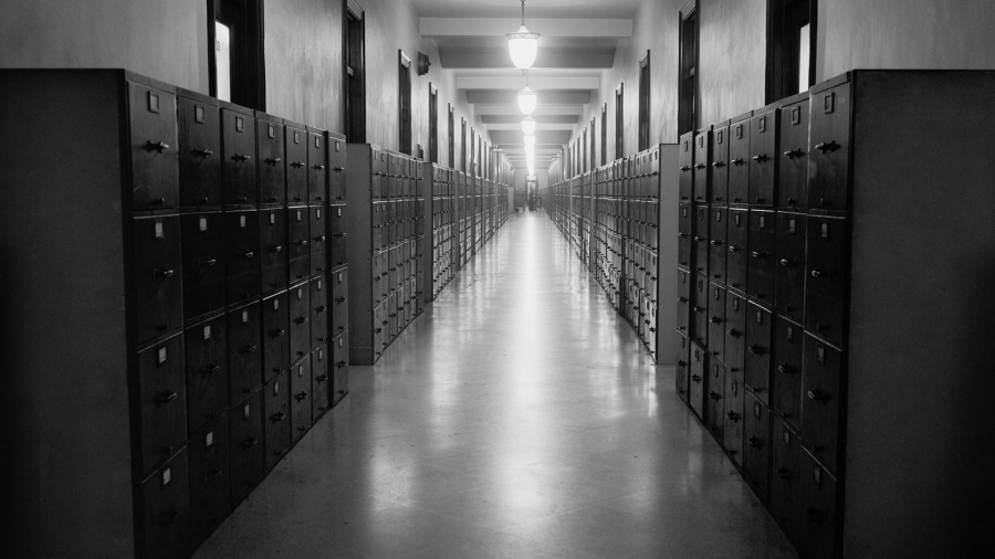 A black-and-white photo of a hallway lined with filing cabinets.