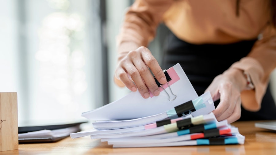 A woman flipping through files on her desk.