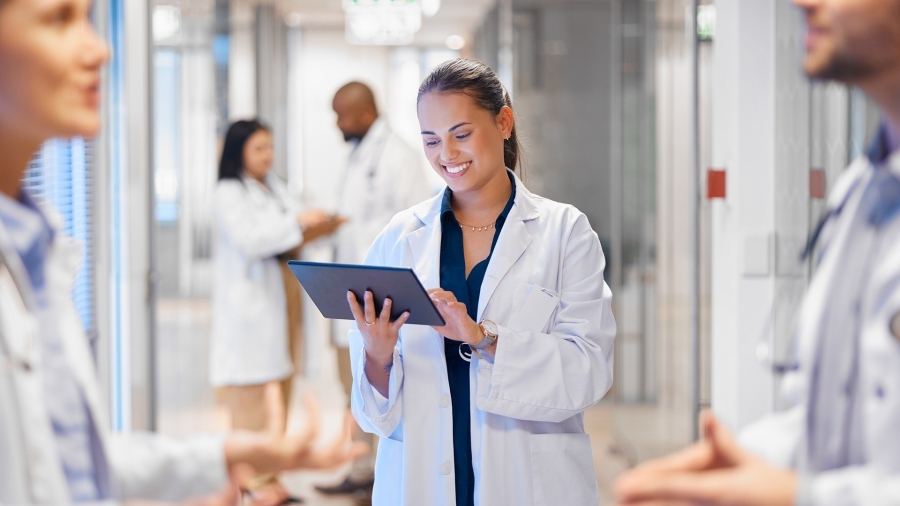 A doctor smiling at an iPad.