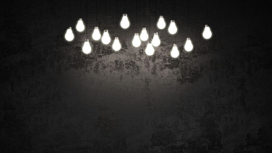 Photo de plusieurs ampoules électriques allumées sur fond sombre.