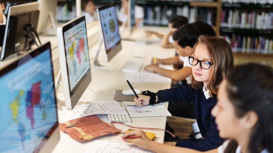 Students in front of computers in a school library.