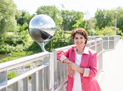 Information and Privacy Commissioner Patricia Kosseim posing for a photo on a bridge, with trees in the background.